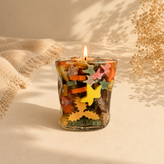 شمع ژلهای دستساز داخل ظرف شیشهای دفرمه با برگهای رنگی پارافینی پاییزی